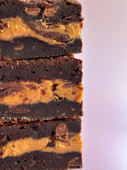 Decadent chocolate gluten-friendly brownies stuffed with a layer or milk chocolate and gooey peanut butter