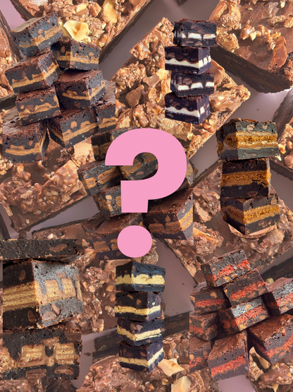 Stacks of fudgy, gooey chocolate brownie stuffed with different biscuits and chocolate bars on a background of chocolate brownies with crushed up Ferrero Rochers on top